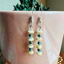 Load image into Gallery viewer, A pair of earrings with a row of colorful beads hanging from the ear hooks, placed on a pink surface.