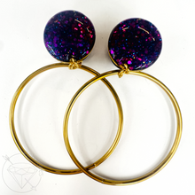 Load image into Gallery viewer, two gold hoop earrings with purple glittery stones attached to them.