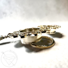 Load image into Gallery viewer, A close-up view of a decorative metal piece, possibly a ring or pendant, with intricate patterns and designs.