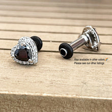 Load image into Gallery viewer, a pair of earrings with a heart-shaped gemstone and a black metal post, resting on a wooden surface.